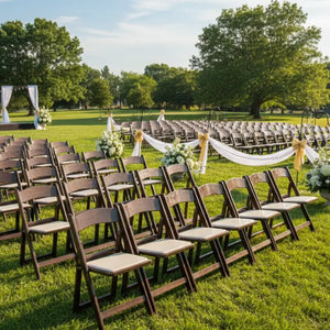 Outdoor wedding setup with rows of chairs and decorations on a grassy field.
